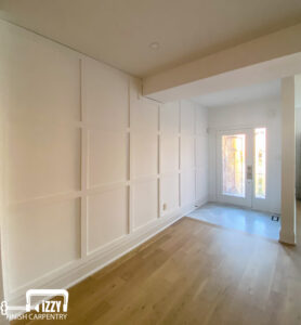 Beautiful home entrance with wooden doors, wainscotting, and baseboards