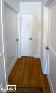 Hall with wooden floors, doors, shoemold, and baseboards