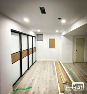 Sliding doors with wood finishes, wood doors in progress, wooden floors, and baseboards