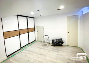 Sliding doors with wood finishes, wood doors in progress, wooden floors, and baseboards