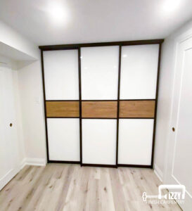 Sliding doors with wood finishes, a normal side doors in progress, wooden floors, and baseboards