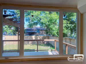 Window with wooden frame and a wooden deck behind it